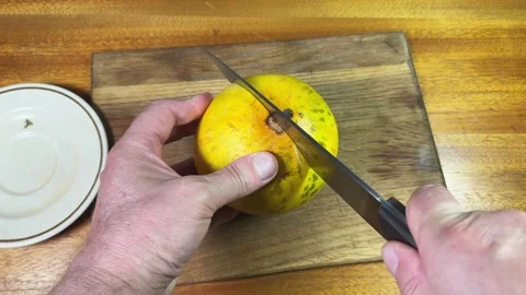 Cutting in half small yellow melon on a cutting board Stock Footage 320256422