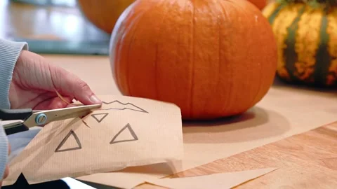 Cutting Halloween Pumpkin Face Template With Scissors Stock Footage 345094638