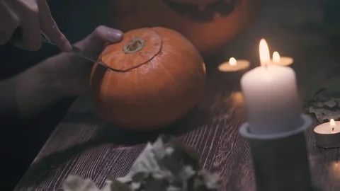 Cutting Halloween Pumpkin Top Part With Knife, Start making jack-lantern, with a Stock Footage 80243295