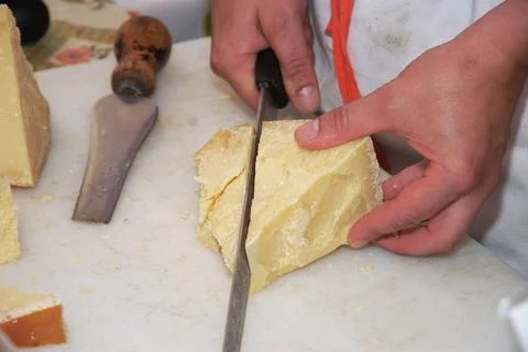  cutting hard cheese Mann schneidet Parmesan auf Markt man cutting Parmeso... Stock Photos