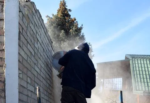 Cutting a hole in the wall using a cutter. Stock Photos