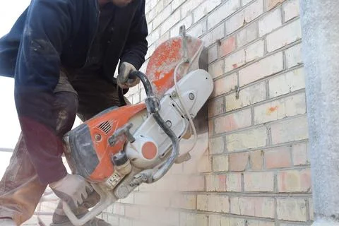Cutting a hole in the wall using a cutter. Stock Photos