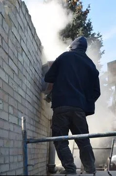 Cutting a hole in the wall using a cutter. Stock Photos