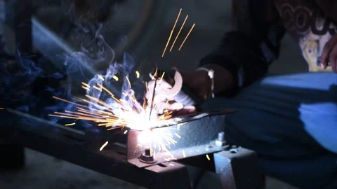 Cutting iron sparks night time workshop brazing metal closeup 4k Stock Footage 97170643