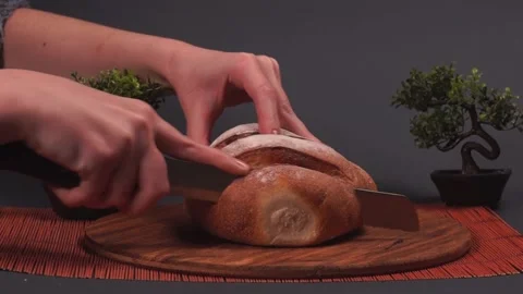 Cutting with a Knife Crusty Artisan Bread in the Kitchen Stock Footage 217408107