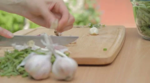 Cutting with knife garlic base and removing dry husks outdoors Stock-Footage 8367617
