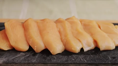 Cutting with knife raw chicken meat on desk close-up. Preparing raw food for Stock Footage 265601182
