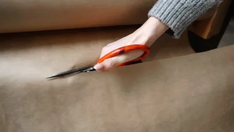 Cutting Kraft Paper Roll with Scissors Stock Footage 315528838
