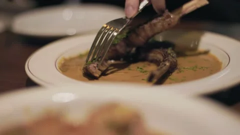Cutting lamb restaurant plate, fork and knife, fine dining. 4K 24FPS Stock Footage 237340627