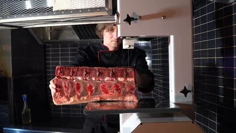 Cutting a large piece of beef with an electric band knife Stock-Footage 85670562