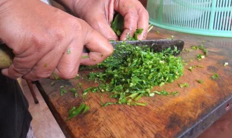 Cutting leaf vegetable to prepare a meal. Stock Photos