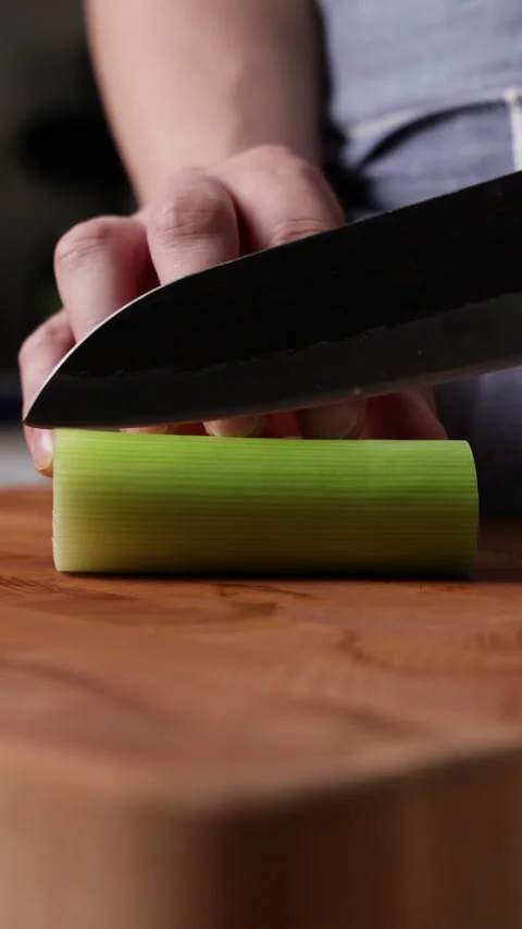 Cutting Leek In Half Front View Vertical Vidéo 337190072