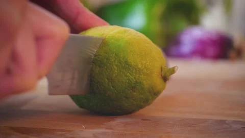 Cutting lemon in two parts with knife on wood board, fresh ingredient for lemon Stock Footage
