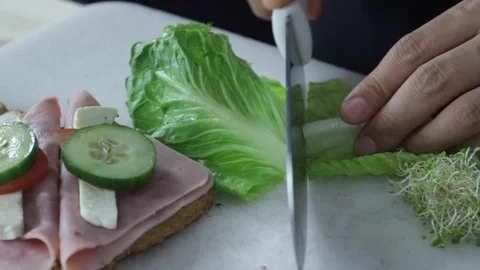 Cutting lettuce to make a sandwich Stock Footage 130060987