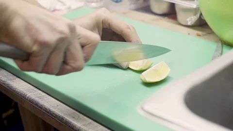 Cutting lime slices on chopping board Stock Footage 106759101