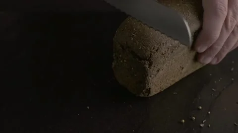 Cutting a loaf of bread with a bread knife Stock Footage 56338111