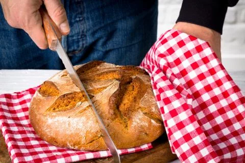 Cutting a loaf of bread into slices Stock Photos