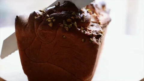 Cutting a loaf of nut bread with a knife Stock Footage 229702149