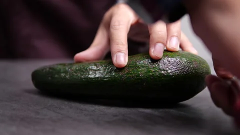Cutting a long avocado on table in slow motion Stock-Footage 137907901