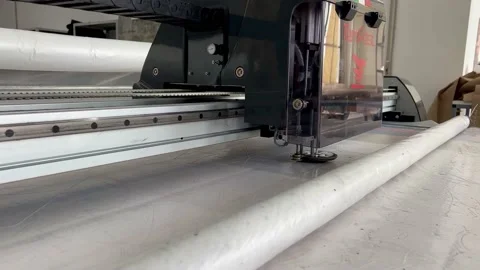 Cutting machine cuts out patterns from fabric at the garment factory Stock Footage 217813445