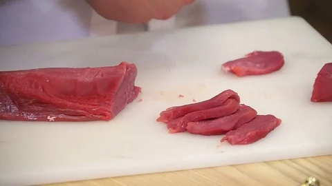 Cutting meat on a  kitchen board Stock Footage 95140097