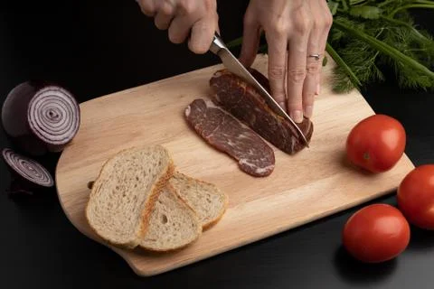 Cutting of meat slices on a kitchen Board. Stock Photos