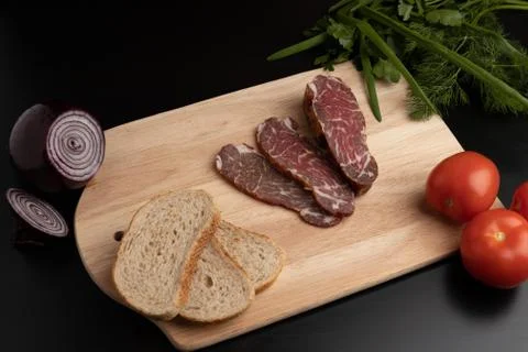 Cutting of meat slices on a kitchen Board. Stock Photos