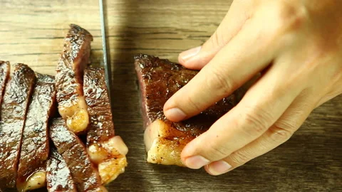 Cutting medium rare sirloin steak on board , in door  Chiangmai  Thailand Stock Footage 134685000