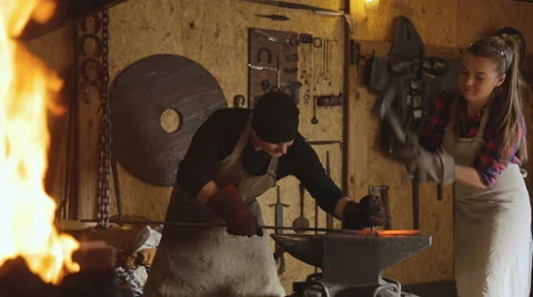Cutting metal by hand forging with help of two people Stock Footage 64195755