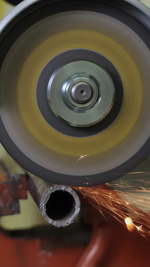 Cutting a metal pipe with an angle grinder creating bright sparks, close-up view Video stock 307954956