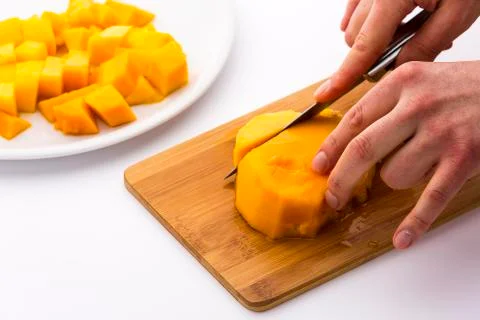 Cutting the middle mango third containing its pit Stock Photos