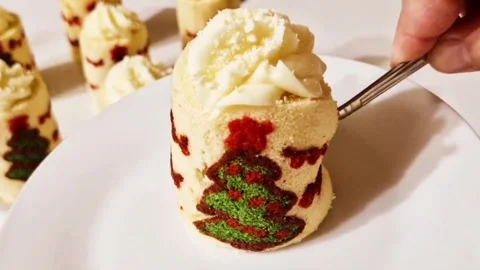 Cutting a mini christmas tree swiss roll cake with a fork to show cream filling Stock Footage 327259458