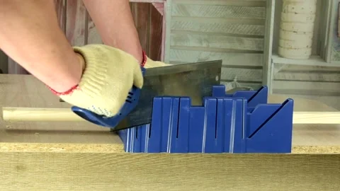 Cutting mitered cuts using saw and mitre box Stock Footage 130471663