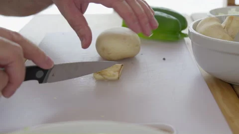 Cutting mushroom tail base with knife men hand on white cutting board with onion Stock Footage 266781149