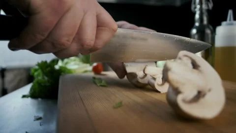 Cutting of mushrooms champignons on a cutting board with a sharp knife Stock Footage 315230307