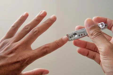 Cutting nails using nail clipper Stock Photos