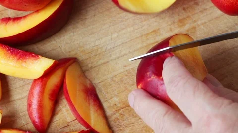 Cutting nectarine into slices closeup Stock Footage 95199427