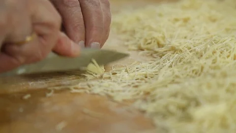 Cutting of noodles roll on cutting board by hands close up Stock Footage 73223412