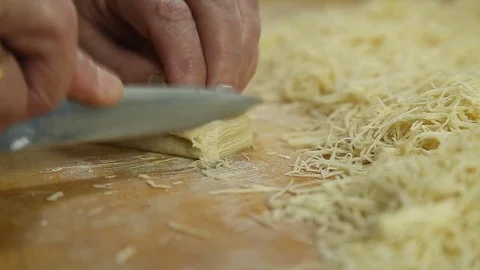 Cutting of noodles roll on cutting board by hands close up Stock Footage 73223423