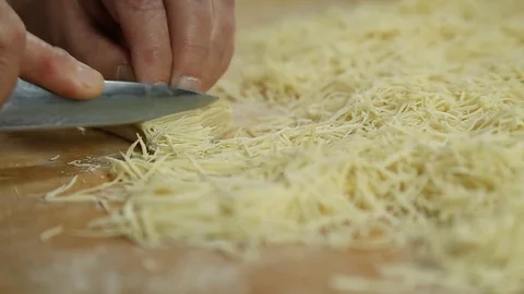 Cutting of noodles roll on cutting board by hands close up Stock Footage 73223453