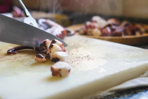 Cutting octopus on kitchen board. Stock Photos