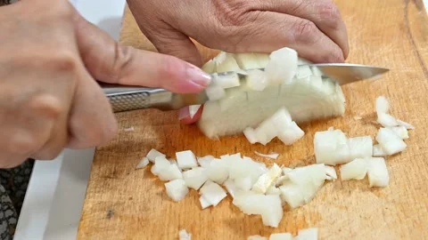 Cutting onion with a knife on a board Stock Footage 219674178