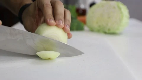 Cutting Onion over a white board with a professional knife. Stock Footage 129044480