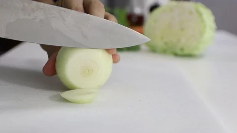 Cutting Onion over a white board with a professional knife. Stock Footage 129249130