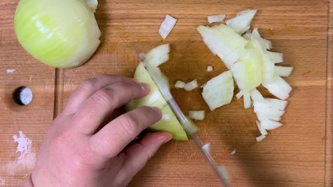 Cutting onions into small cubes with a knife on a wooden cutting board. Top view Stock-Footage 301889961