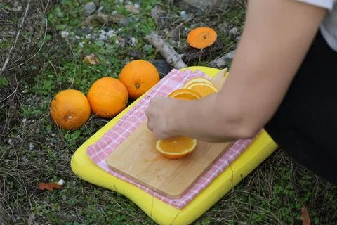 Cutting orange outdoors Фото