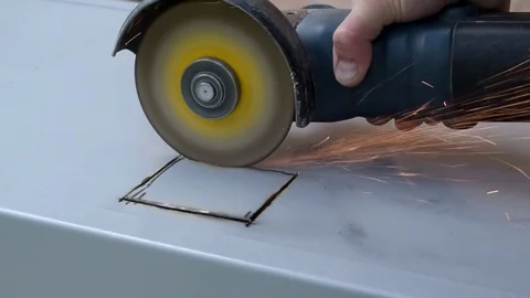 Cutting out a hole in metal with angle grinder Stock Footage 76963909