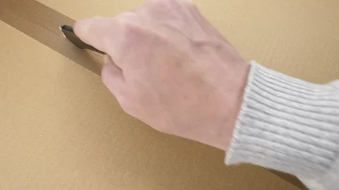 Cutting packing tape vertically on cardboard box Stock Footage 325037625