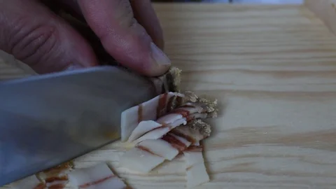 Cutting pancetta, cured bacon Stock Footage 105472791