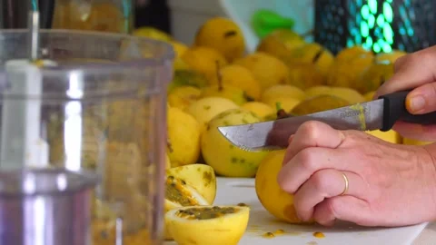 Cutting passion fruit for processing in a home kitchen on Hawaii Stock Footage 252915341
